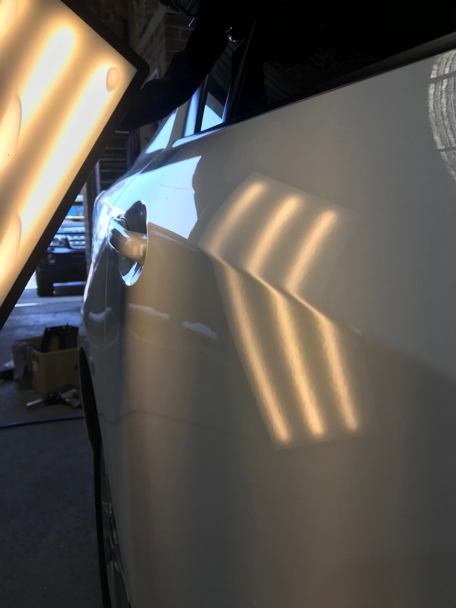 After photo showing the white vehicle door after the dent was repaired
