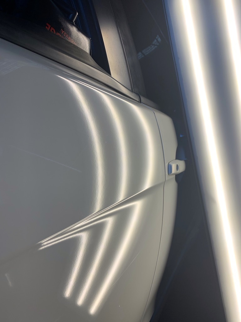 After photo showing the white vehicle door after Dent X paintless dent repair